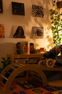 Warmly lit interior photography of a cozy living space with wall art, plants, and wooden furniture